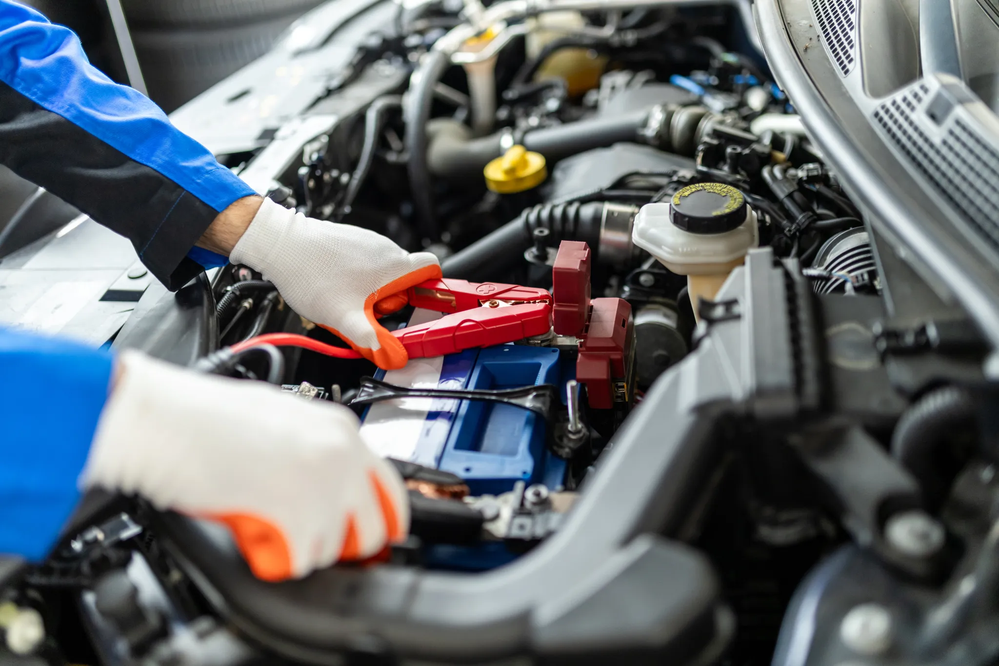 Professional roadside technician providing a car battery jump start service to a stranded vehicle in Waukegan, IL.